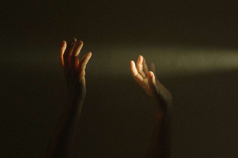 hands in darkness seeking light